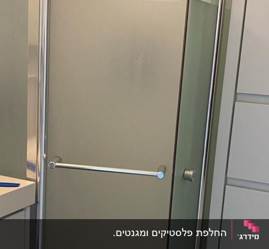 מקלחון זכוכית עם דלתות מתכת וברז מקלחת